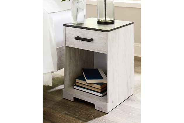Give provincial a new meaning with the chic look of the Shawburn nightstand. The two-tone finish keeps this piece light and fresh while the warm pewter-tone hardware adds an industrial touch. The open cubby provides display space or accommodates a storage bin to add a delightfully homespun charm to your space.Made with engineered wood (MDF/particleboard) and decorative laminate | Whitewash replicated worn through paint | Top with rustic gray planked replicated oak grain with authentic touch | Pewter-tone pulls | One smooth-gliding drawer | Open storage cubby | Vinyl wrapped drawer sides and back for extra durability | Assembly required | Estimated Assembly Time: 20 Minutes
