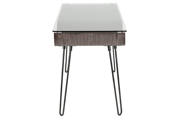 Feel free to bend the rules with this mixed media home office desk. A unique merger of mid-century inspiration and urban attitude, it’s dressed to impress with curvaceous bent wood, hairpin legs and a clear tempered glass top. What a great choice for small spaces!Metal hairpin legs in black | Tempered glass top | Bent wood storage shelf with charcoal finish | Assembly required