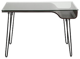 Feel free to bend the rules with this mixed media home office desk. A unique merger of mid-century inspiration and urban attitude, it’s dressed to impress with curvaceous bent wood, hairpin legs and a clear tempered glass top. What a great choice for small spaces!Metal hairpin legs in black | Tempered glass top | Bent wood storage shelf with charcoal finish | Assembly required