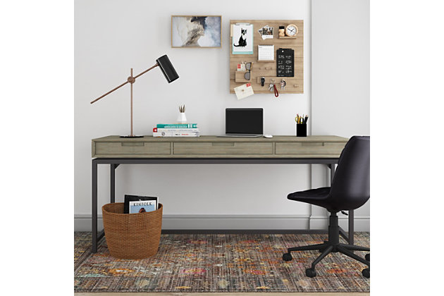 Get down to work in a high-style way with this modern industrial desk by Simpli Home. A striking example of mixed-material design, it simply wows with a richly grained wood top beautified with a distressed gray finish. An ultra-linear black metal base provides sturdy support and a sleek aesthetic. Adding to this home desk’s streamlined appeal: subtle cutouts in lieu of traditional drawer pulls for a less-is-more sensibility.DIMENSIONS: 24" D x 72" W x 31.5" H | Handcrafted with care using the finest quality solid Rubberwood and 1.2 inch Blackened Metal | Hand-finished in Distressed Grey and a protective NC lacquer to accentuate and highlight the grain and the uniqueness of each piece of furniture | Multipurpose desk adds function and style without overwhelming the space. Looks great in your living room, family room, home office, bedroom or condo. Provides plenty of space for office work, studying, writing or gaming | Features: two notched handle side drawers with ball bearing drawer glides and one center flip down drawer/keyboard tray | Modern Industrial style includes metal frame and legs | Assembly Required | We believe in creating excellent, high quality products made from the finest materials at an affordable price. Every one of our products come with a 1-year warranty and easy returns if you are not satisfied.
