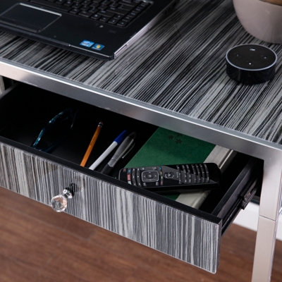 Open drawer with desk items including remote and pencils
