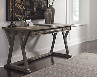 Work the latest trend in casual farmhouse living with the Luxenford home office desk. Elements include distinctive cross brace with stretcher styling and a wire brushed gray-brown finish that’s so easy on the eyes. Making this home office desk all the more unique: a faux bluestone inset on the desk top for a mixed media twist. Three smooth-gliding drawers with brushed nickel-tone pulls help keep you organized and on task.Made of white oak veneers, wood and engineered wood | Desk top with faux bluestone inset | Wire brushed gray-brown finish with metallic undertones | 3 smooth-gliding drawers | Brushed nickel-tone hardware | Assembly required | Estimated Assembly Time: 30 Minutes