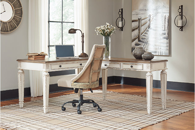 Elevating the art of traditional cottage styling, the Realyn L-shaped desk is your heavenly home office realized. Two-tone finish combines chipped white with distressed wood tone tops for added charm. Framed drawer fronts, decorative corbels and elegantly turned and tapered legs add refinement, while dark bronze-tone knobs lend a classic touch. Spring lift top raises the surface to a comfortable standing position, for a healthy alternative. Built for looks and productivity, the built-in power supply and dual USB ports keep your devices close at hand and ready to go.Includes desk and desk return  | Made of wood, engineered wood and veneers, with cast resin components | Antiqued two-tone finish | Return with 2 smooth-gliding drawers with dovetail construction | Desk with spring lift top and drop-front drawer | Return with cutout for cord management | Dark bronze-tone finished metal hardware | 2 AC electrical plug-ins and 2 USB slots | Power cord included; UL-listed | Assembly required | Estimated Assembly Time: 50 Minutes