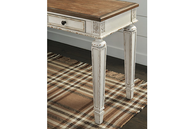 Elevating the art of traditional cottage styling, this designer desk is your heavenly home office realized. Antiqued two-tone aesthetic blends a chipped white with a distressed wood tone top for added charm. Framed drawer fronts, decorative corbels and elegantly turned and tapered legs add refinement, while dark bronze-tone knobs lend a classic touch.Made of wood, engineered wood and veneers, with cast resin components | Antiqued two-tone finish | 2 smooth-gliding drawers with dovetail construction | 1 drop-down drawer front | Dark bronze-tone finished metal hardware | Includes AC power supply | USB Charging | Assembly required | Estimated Assembly Time: 15 Minutes