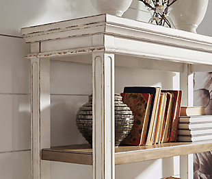 Elevating the art of traditional cottage styling, the Realyn bookcase is your heavenly home office realized. Antiqued two-tone aesthetic blends a chipped white with a distressed wood tone top for added charm. Clever balance of shelf and drawer space beautifully works.Made of wood, engineered wood and veneers | Antiqued two-tone finish | Smooth-gliding drawer with dovetail construction | 3 fixed shelves | Dark bronze-tone finished metal hardware | Estimated Assembly Time: 30 Minutes