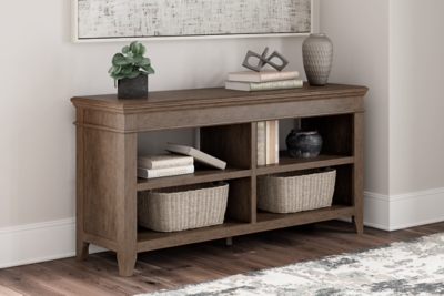 The Janismore Weathered Gray Home Office Storage Leg Desk is available at  Discount Furniture Center proudly serving South Hill and Farmville, VA and  surrounding areas!