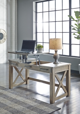 Crafted with pine veneers and wood treated to a distressed gray finish, the Aldwin lift top desk is rustic farmhouse living at its best. Crossbuck styling adds striking flair, while metal industrial brackets incorporate an industrial twist. Elevating the functionality of this lift top desk all the more: two smooth-gliding drawers and conveniently placed AC power/USB plug-ins.Made of pine veneers, pine wood and engineered wood | Distressed gray finish | Metal bracket accents | 2 smooth-gliding drawers with dovetail construction | 2 electrical outlets and 2 USB charging ports | Power cord included; UL Listed | Spring lift top | Assembly required | Estimated Assembly Time: 30 Minutes