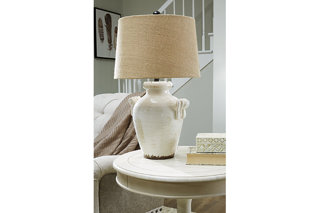 Emelda table lamp illuminates with vintage-inspired style. Antiqued cream glazed ceramic base boasts a crackle effect. Vase shape with the appearance of handles sits beautifully on end table. Perfect for farmhouse and cottage chic spaces.Made of glazed ceramic with fabric modified drum shade | 3-way switch | 1 type A bulb (not included); 100 watts max or CFL 23 watts max; UL listed | Assembly required | Clean with a soft, dry cloth | Estimated Assembly Time: 15 Minutes