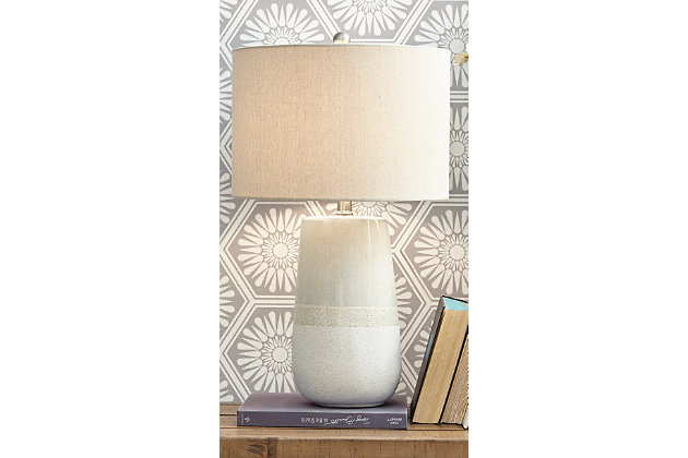 With a textured neutral glaze, the Shavon table lamp brings thoughts of sun, surf and sand to your space. Turn coastal chic to the contemporary side with this transitional lamp.Made of glazed ceramic with fabric drum shade | 3-way switch | 1 type A bulb (not included); 150 watts max or 25 CFL watts max; UL Listed | Assembly required | Estimated Assembly Time: 15 Minutes