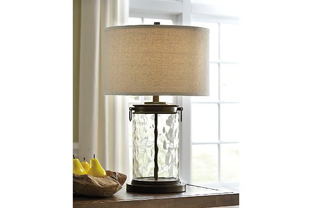 Light waves ahead. Wowing with a clear wave glass design, the Tailynn table lamp is delightfully chic and unique. Classic drum shade is perfectly in tune with cylinder shape base.Made of wave glass and metal with fabric drum shade | 3-way switch | 1 type A bulb (not included); 150 watts max or 25 watts max CLF; UL Listed | Clean with a soft, dry cloth | Assembly required | Estimated Assembly Time: 15 Minutes