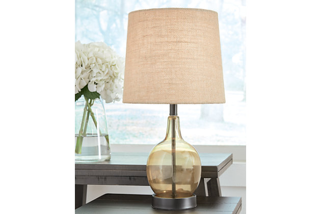 The Arlomore table lamp is the perfect combination of form and function, bringing lighting and chic style to any interior. The curvaceous lamp is crafted of amber glass for modern flair and is topped with a natural jute shade.Made of glass and metal with  modified drum hardback fabric shade | Transparent amber and black finish | On/off switch | 1 E26 socket; type A bulb recommended (not included); 60 watts max or CFL 13 watts max; UL Listed | Assembly required