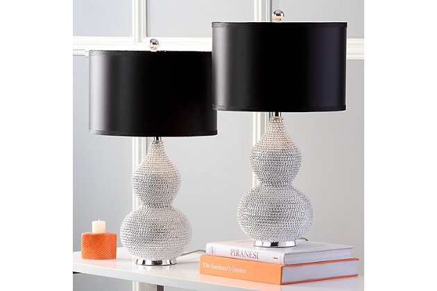 Let your room radiate in the shimmery glamour of this beaded table lamp set. Crafted of poly resin with a double gourd body, this shapely duo is completely encrusted with tiny silvertone beads. Topped with a black satin shade for clean, modern polish.Set of 2 | Made of resin with fabric shade | On/off switch | Cfl bulb; 13-watt bulb included | Wipe with a soft, dry cloth; avoid use of chemicals and household cleaners as they may damage finish | Assembly required