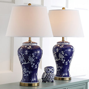 Winding branches bursting with white flower buds adorn this classically styled table lamp. True to its roots in Asian design, this elegant urn-shaped lamp is crafted of ceramic with a fabric drum shade and gilded accents.Set of 2 | Made of ceramic with cotton shade | 1 type a bulb (not included); 40 watts max or cfl 13 watts max | Assembly required | Clean with a soft, dry cloth