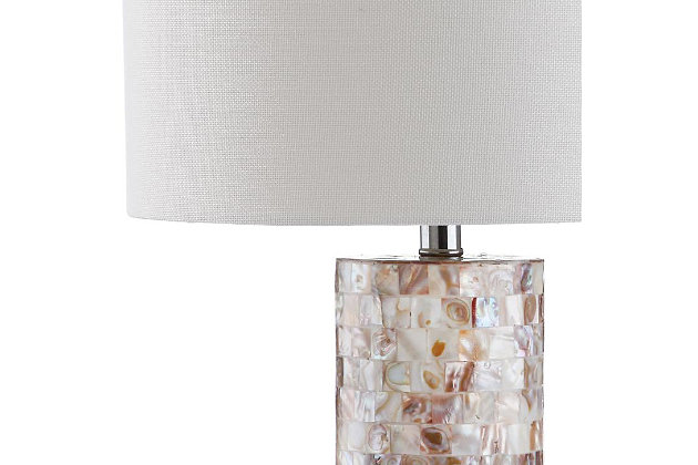 Fresh as an ocean breeze, this shell lamp adds just the right touch of glimmer beside a sumptuously decorated bed, or sophisticated sofa or chair. Crafted of natural capiz shell, the cylindrical base is accented with a silvertone neck and an ivory cotton shade.Set of 2 | Made of shell with cotton shade | 1 type a bulb (not included); 40 watts max or cfl 13 watts max | Assembly required | Clean with a soft, dry cloth