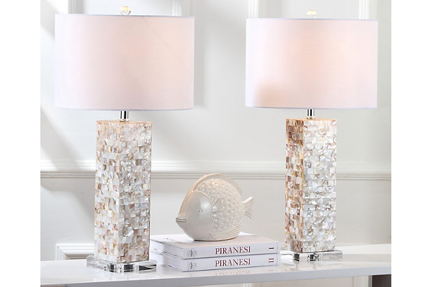 Fresh as an ocean breeze, this shell lamp adds just the right touch of glimmer beside a sumptuously decorated bed, or sophisticated sofa or chair. Crafted of natural capiz shell, the rectangular base is accented with a silvertone neck and an ivory cotton shade.Set of 2 | Made of shell with cotton shade | 1 type a bulb (not included); 40 watts max or cfl 13 watts max | Assembly required | Clean with a soft, dry cloth