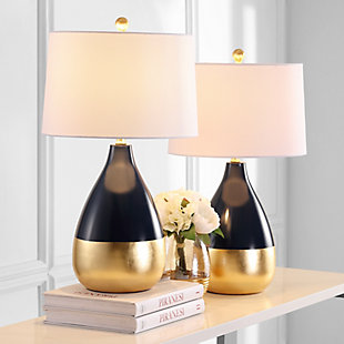 The decadent decor of a London designer’s lush home inspired this navy and goldtone table lamp. Place on either side of a living room armoire for a radiant focal point that speaks to the educated eye or use in the boudoir for an opulent touch.Set of 2 | Made of metal with cotton shade | 1 type a bulb (not included); 40 watts max or cfl 13 watts max | Assembly required | Clean with a soft, dry cloth