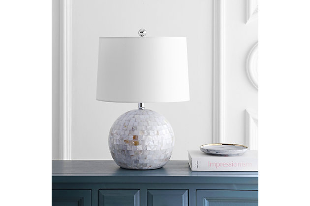 Inspired by the opulent discoveries of ancient pearl divers working in the Mediterranean, this luxurious contemporary shell table lamp is a new-found treasure. Finished in an elegant ivory color, its brilliant shine brings depth and character to any room.Made of shell with fabric shade | 1 type a bulb (not included); 40 watts max or cfl 13 watts max | Assembly required | Clean with a soft, dry cloth
