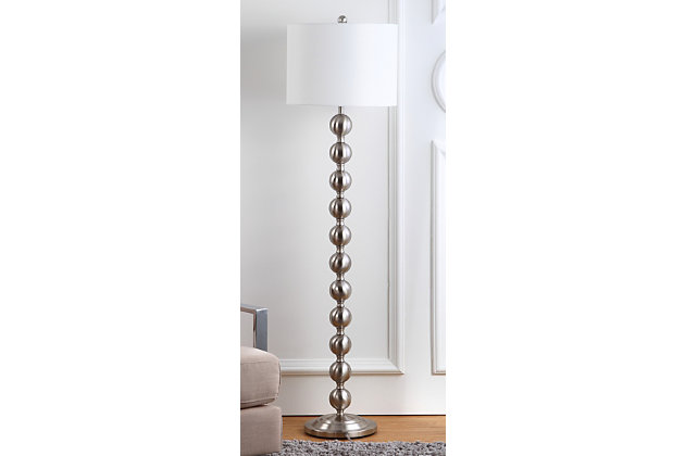 The homes and movie sets of Old Hollywood inspired this posh stacked-ball floor lamp. Its shining nickel-tone base and white cotton drum shade add instant glamour to any interior.Made of metal with fabric shade | Nickel-tone finish | 1 spiral CFL E-26; 13-watt max bulb | On/off switch | Wipe with a soft, dry cloth; avoid use of chemicals and household cleaners as they may damage finish | Assembly required