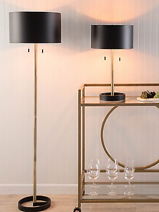 Chic, bold and classy—this refined table lamp draws inspiration from the Art Deco movement. Showcasing a sleek metal shade, two hanging pull chains and a luxurious gold finish, this lamp lights the way to lovely decor.Made of metal | Black and goldtone finish | Sturdy metal base | Metal drum-shaped shade | Pull chain switch | Indoor use only | Requires two 60-watt bulbs (not included) | Ul listed | Assembly required