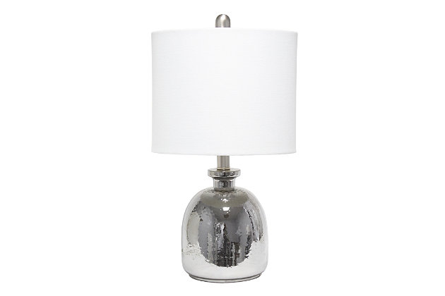 With a textured glass base and white fabric drum shade, this lamp is sure to update any room in your home with a little charm.  This lovely lamp is crafted with an open bottom glass base in a silver metallic color. Perfect for adding the little refresh to your living room, bedroom, foyer or office that you've been looking for!Fabric white shade | Metallic silver glass base | 1 x 60w medium type a base bulb (not included) required | More shade color options available!
