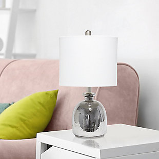 With a textured glass base and white fabric drum shade, this lamp is sure to update any room in your home with a little charm.  This lovely lamp is crafted with an open bottom glass base in a silver metallic color. Perfect for adding the little refresh to your living room, bedroom, foyer or office that you've been looking for!Fabric white shade | Metallic silver glass base | 1 x 60w medium type a base bulb (not included) required | More shade color options available!