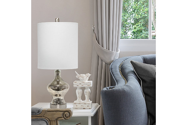 Simple and elegant, this lamp is sure to make a tasteful update to any room in your home.  This lamp features a beautifully shaped mercury glass base complimented by a white fabric drum shade. Rejuvenate your living room, bedroom, foyer or office with this trendy lamp!Fabric white shade | Beautifully shaped mercury glass base | 1 x 60w medium type a base bulb (not included) required | More base color options available!