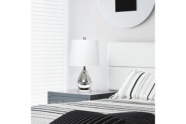 Enhance your room with this stylish chrome glass lamp.  The white fabric shade is the perfect compliment to the base with its' lustrious finish and subtle ripple design.  Perfect for your living room, bedroom, office or anywhere you need to add a touch of sparkle!Fabric white shade | Chrome glass base with subtle ripple design | 1 x 60w medium type a base bulb (not included) required | More shade color options available!