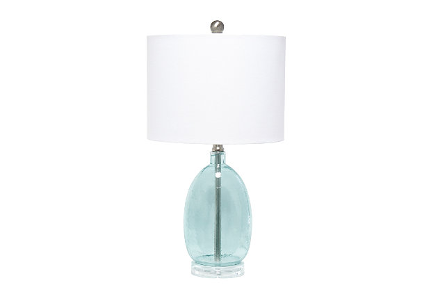 Enhance any room in your home with this simple yet chic table lamp.  The oval shaped base features textured clear blue glass accented with brushed nickel and a white fabric drum shade.  Perfect for your living room, bedroom, office, or anywhere you need to add a tasteful update!Fabric white shade | Textured clear blue glass base | 1 x 60w medium type a base bulb (not included) required | 5 foot clear cord