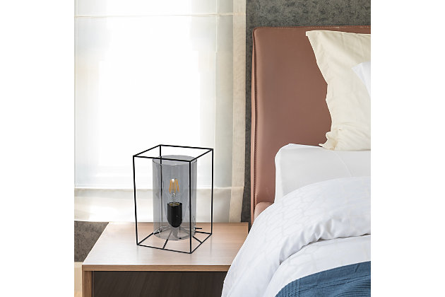 This table lamp features a black metal frame with a smokey glass shade that will illuminate any room in style!  The simple, clean lines of the frame is complimented by the rounded cylinder shade offering a chic sophisticated look.  Perfect for your living room, bedroom, office, apartment or college dorm!

**HELPFUL TIP: To get the complete industrial look, we recommend using a decorative Edison/Vintage bulb (not included). **Cylindrical smokey glass shade | Rectangular black metal frame | 1 x 40w medium type a base bulb (not included) required

for full vintage look, type t45 edison bulb is recommended | 5 foot black cord
