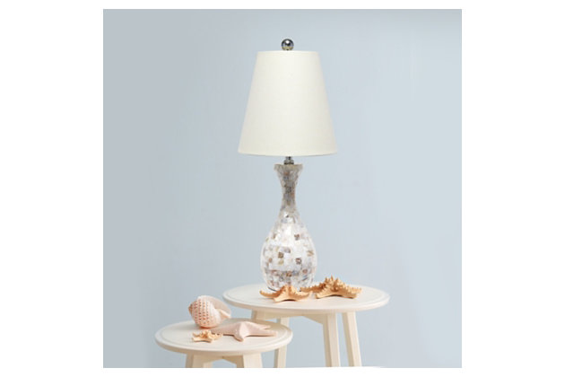This trendy table lamp features a stylish Capiz shell look tiled in a mosaic pattern.  Constructed from beautiful muted shades of coral, gray and white, this lamp is accented with an immaculate chrome finish and a fresh cream fabric shade. These slightly iridescent tiles and natural tones will add elegance and glamour to any room.  Enhance your room with style and finesse with this simply beautiful table lamp!Immaculate chrome finish accents | Fresh cream fabric shade | 1 x 2-way 60w type a medium base bulb required  (not included) | The curvy lamp base is beautifully wrapped in capiz shell tile look creating an exquisite mosaic pattern.