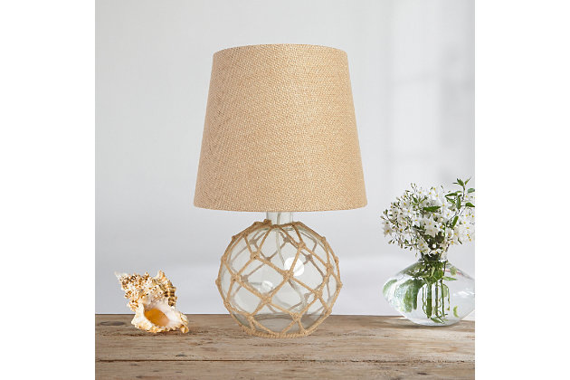 If you have that lovely beach house, condo, or rental you're looking to decorate, check out this nautical table lamp fitting for your coastal decor!  The clear glass base is netted in a natural rope, complemented by a burlap empire fabric shade.  This lamp is just over a foot tall making ideal to sit on your nightstand, dresser, in your living room, entry way, and just about any room in your home!Clear glass base wrapped in natural rope | Burlap empire fabric shade | Uses 1 x 60w type a medium base bulb (not included) | On/off switch located conveniently on the cord