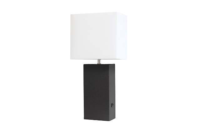 This simple yet modernized table lamp showcasing a leather body and white fabric shade is the perfect addition to your lighting needs. With a USB port on the side of the base, you are able to conveniently plug and/or charge your devide. Our products are designed to enhance your room with elegance and sophistication.Leather wrapped base with usb port | White fabric shade | Assembled dimensions: l: 10" x w: 6" x h: 21" | Uses 1 x 60w type a base bulb (not included)