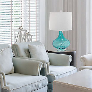 Illuminate your living space in style with this beautifully designed glass table lamp.  The light blue drapery-like glass and white fabric shade is the perfect blend to give your home a tasteful décor upgrade.Light blue glass base with draping detail | White fabric drum shade | 8" harp & finial shade security with rotary switch on socket | Uses 1 x 150W E26 3-way Medium base bulb (not included)