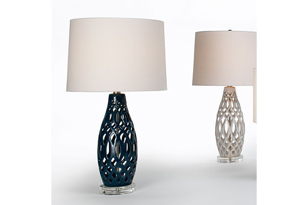 In a labyrinth of ceramic tracery, this table lamp's hollow center breathes new life into the average lamp silhouette. Its almost-woven aesthetic embraces the absence of a weighted center and instead looks light and airy. The lamp's acrylic base and white linen shade speak to its visually weightless nature.Made of ceramic with fabric shade | 3-way switch | Type E26 bulb (not included); 100 watts max; UL Listed | Clear cord | No assembly required