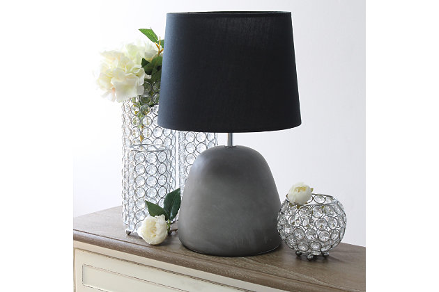 Simple yet stylish, this table lamp features a rounded gray concrete base complimented by a black fabric shade.  The perfect table lamp for an easy upgrade to give your home a sophisticated modern look!  Ideal for your living room, bedroom, office or entryway.Gray concrete base | Black fabric tapered shade | Easily accessible rotary switch on cord | Uses 1 x 60w medium type a base bulb (not included) | Lamp measures l: 10.25" x w: 10.25" x h:16.50" | Sophisticated & modern