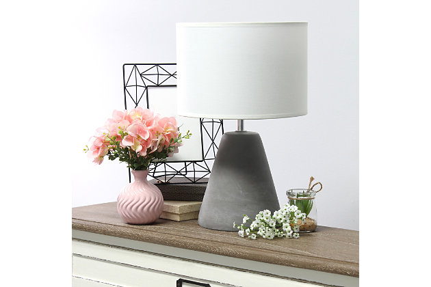 The perfect table lamp for an easy upgrade to give your home a sophisticated modern look!  Simple yet stylish, this table lamp features a cone like gray concrete base complimented by a white fabric shade.  Ideal for your living room, bedroom, office or entryway.Gray concrete base | White fabric drum shade | Easily accessible rotary switch on cord | Uses 1 x 40w type b candelabra base bulb (not included) | Lamp measures l: 9" x w: 9" x h:14.20" | Sophisticated & modern