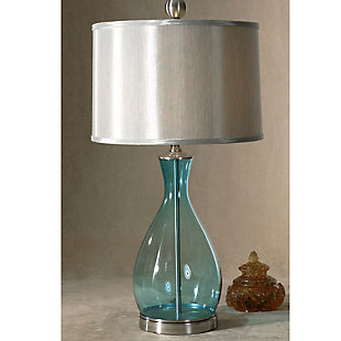 The clear blue mouth-blown glass body of this pretty table lamp coordinates perfectly with the satin nickel-tone metal detail of the neck and base. A silken silver-gray hardback shade adds a sophisticated touch. Perfect for a sofa-side table or reading table, this lamp is sure to complement your decorating scheme no matter where you put it.Made of glass, metal and fabric | Mouth-blown glass body with clear blue finish | Nickel-tone metal finish | Round hardback drum shade with silken silver-gray fabric | 3-way switch | Type a bulb; 150 watts max (not included)
