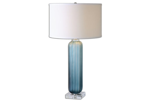 Put your decor in the best light possible with this table lamp. Its crudely grooved frosted blue glass is paired with polished nickel-plated accents and crystal details. A round hardback drum shade in crisp off-white linen fabric completes the lamp's striking look.Made of glass, metal, crystal and fabric | Glass base with frosted blue finish | Polished nickel-plated accents | Crystal details | Round hardback drum shade with off-white linen fabric | 3-way switch | Type a bulb; 150 watts max (not included)