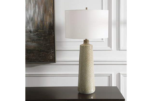The ceramic body of this earthy table lamp is finished in a sage green glaze with a light tan wash, accented by light brushed brass-plated metal details. The colors and porous texture of the glaze offer a charmingly warm, natural effect, complemented by a crisp white linen shade.Made with ceramic, metal and fabric | Uses one type a bulb (150-watt, 3-way); sold separately