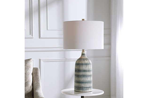 This casual, textured ceramic table lamp features a mixture of blue and white asymmetrical stripes, with brushed nickel-plated accents. The round hardback drum shade is a white linen fabric.Made with ceramic, metal and fabric | Uses one 150-watt bulb; sold separately