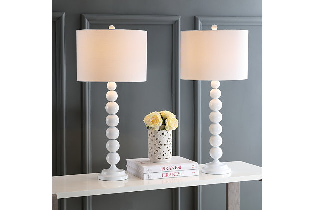 Light up your life with the perfect symmetry of this gleaming white stacked ball lamp. The tall, lean silhouette adds height on a console or hall table, and the uniform color of the base, neck and finial are complemented by the off-white cotton drum shade. Set of 2 | Made with iron; 100% cotton shade  | Includes 2 CFL bulbs | 13W max | On/off switch  | 5' cord | Assembly required | Imported