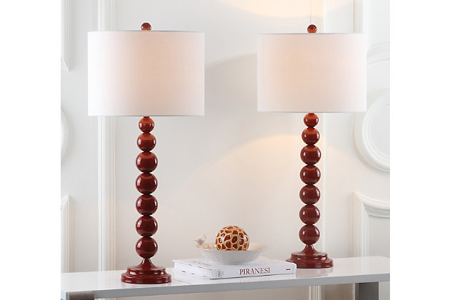 Light up your life with the perfect symmetry of this gleaming red stacked ball lamp. The tall, lean silhouette adds height on a console or hall table, and the uniform color of the base, neck and finial are complemented by the off-white cotton drum shade. Set of 2 | Made with iron; 100% cotton shade  | Includes 2 CFL bulbs | 13W max | On/off switch  | 5' cord | Assembly required | Imported