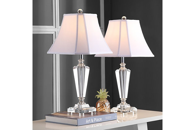 A classic style with timeless appeal, the many-faceted Lilly crystal table lamp will enhance glamorous rooms from art deco to transitional. With silver fittings and a white linen-weave cut-corner shade, this lamp casts a refined glow on tables of any color or finish.Set of 2 | Made with crystal and metal; cotton/polyester shade | Includes 2 cfl bulbs | 13w max | On/off switch | 5' cord | Assembly required | Imported