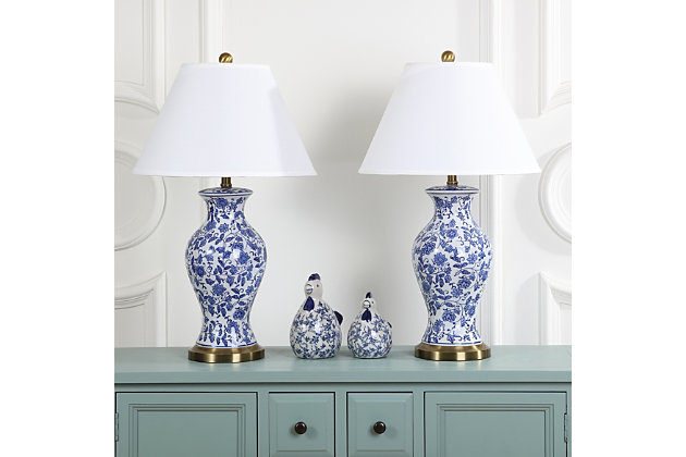 Wandering flowers and vines adorn the Beijing Floral urn lamp, a classic Chinoiserie style in blue and white. Crafted of glazed ceramic and accented with an antique gold base and neck, this artful lamp casts a warm, alluring glow in traditional rooms.Set of 2 | Made with ceramic and metal; 100% cotton shade | Includes 2 CFL bulbs | 13W max | On/off switch  | 5' cord | Assembly required | Imported