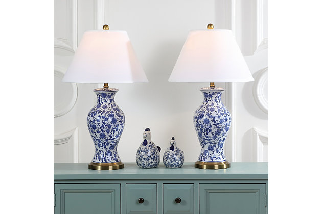 Wandering flowers and vines adorn the Beijing Floral urn lamp, a classic Chinoiserie style in blue and white. Crafted of glazed ceramic and accented with an antique gold base and neck, this artful lamp casts a warm, alluring glow in traditional rooms.Set of 2 | Made with ceramic and metal; 100% cotton shade | Includes 2 CFL bulbs | 13W max | On/off switch  | 5' cord | Assembly required | Imported