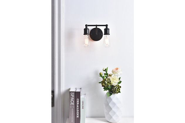 Add a graceful allure to your home with the classical elegance of the Serif Collection wall lamp. Its arms, reminiscent of a classical font, support two lights that emit a reassuring brilliance. With its gentle presence, this light is a wonderful fixture to greet your guests at the entryway, illuminate your nightstands in the bedrooms, or shine in the powder room.Made of metal | two-light wall sconce with circular backplate | Requires 2 E26 bulbs (sold separately) | Exposed bulbs (no shades) | Wall sconce extension: 6.3" | Dimmable | No assembly required | Imported
