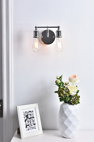 Add a graceful allure to your home with the classical elegance of the Serif Collection wall lamp. Its arms, reminiscent of a classical font, support two lights that emit a reassuring brilliance. With its gentle presence, this light is a wonderful fixture to greet your guests at the entryway, illuminate your nightstands in the bedrooms, or shine in the powder room.Made of metal | two-light wall sconce with circular backplate | Requires 2 E26 bulbs (sold separately) | Exposed bulbs (no shades) | Wall sconce extension: 6.3" | Dimmable | No assembly required | Imported