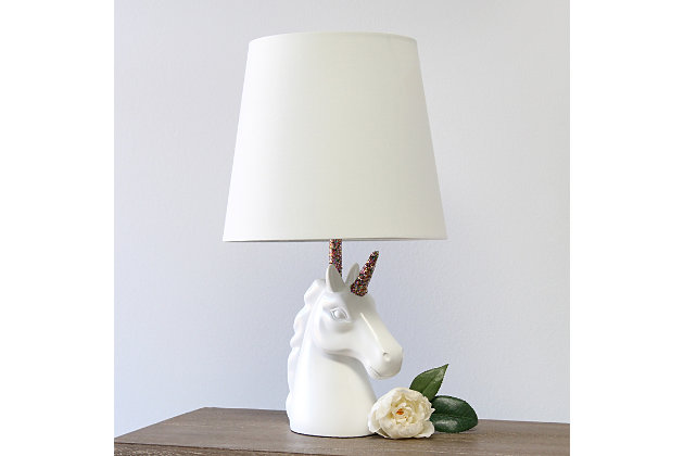 Add a touch of personality to your decor with this fun unicorn lamp. With a white resin base and touches of shimmering rainbow glitter, this lamp is sure to illuminate any room in style. Perfect for bedrooms, kids and teens, college dorms or nurseries.White and rainbow glitter resin base | White tapered fabric shade | Unicorn's horn and neck of lamp coated in shimmering rainbow glitter | Uses (1) 40w type a medium base bulb (not included) | Easily accessible rotary switch located on the cord