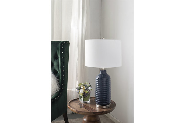 Satisfying both function and form, this ceramic table lamps provide a classic, refined look with a textured element. Providing the perfect finishing touch for any bedroom, desk or living space, the cool and airy ambiance makes it ideal to take center stage in your living space.Made of ceramic and metal with harback fabric shade | Blue finish | Metal base with silvertone finish | Rotary switch | 1 type E26 bulb (not included); 60 watts max; UL Listed | Indoor use only | Imported | Assembly required