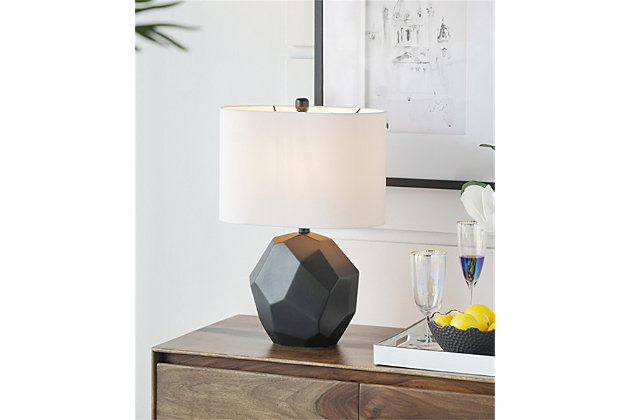This unique table lamp features a gloss black ceramic with embossed geometric patterns accented with a round black finial. The white oval shaped hardback fabric shade provides just the right contrast that's brilliantly suited for giving rich complexity to sophisticated modern decor.Made of ceramic with hardback fabric shade | Black finish | Rotary switch | 1 type E26 bulb (not included); 60 watts max; UL Listed | Indoor use only | Imported | Assembly required